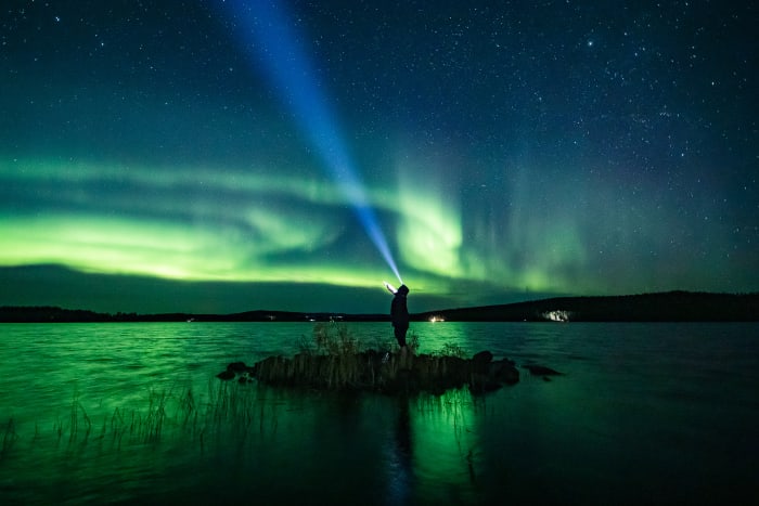 Autumn Northern Lights reflected double on the lake surface, in Rovaniemi